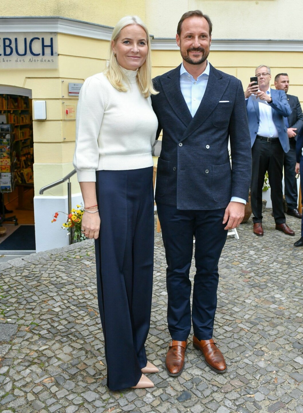 Mette-Marit i vida blå byxor, vit topp från Co och pumps från Louboutin. Credit: UFO No More. Mette-Marit