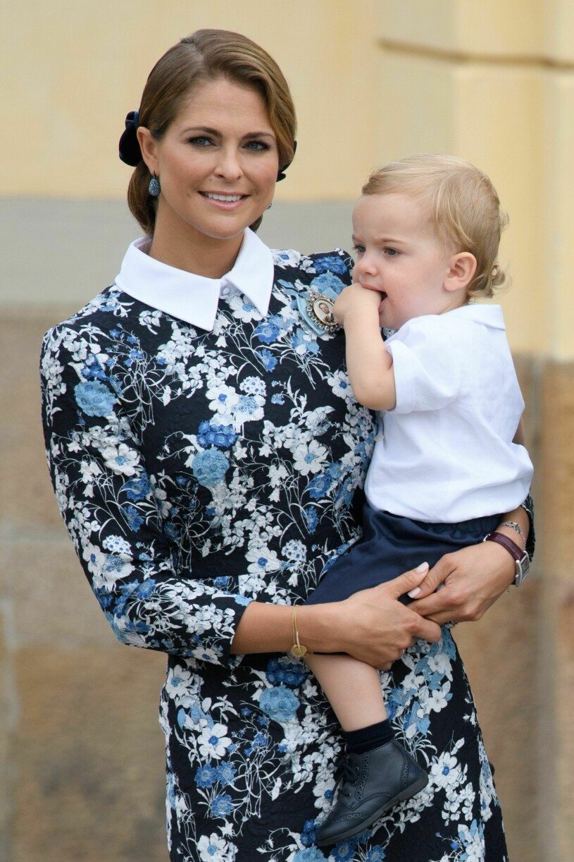 Prinsessan Madeleine som bär en liten prins Nicolas i famnen på prins Alexanders dop 2016