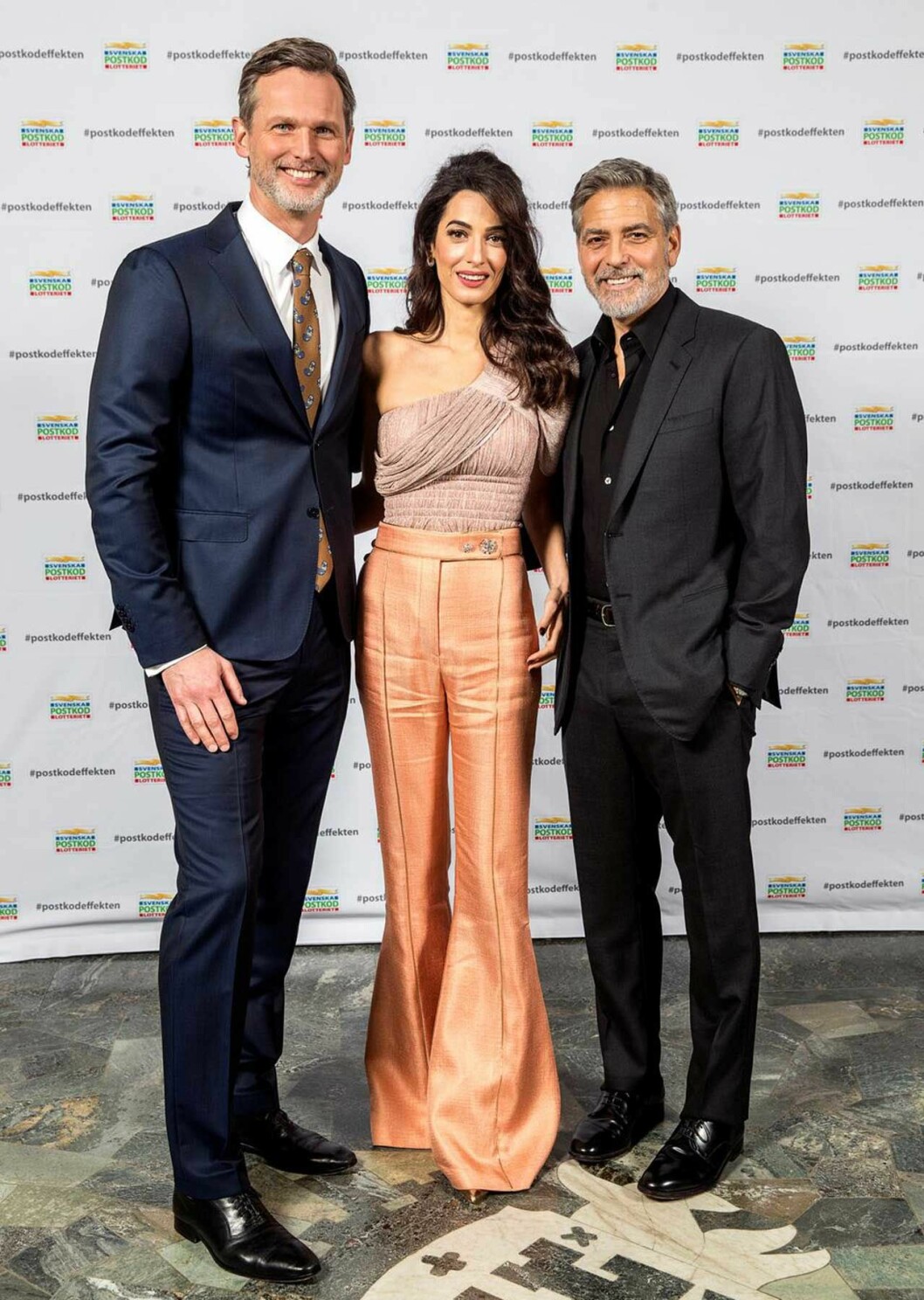 Glammigt värre när Postkodlotteriet delade ut 2018 års överskott! George och Amal Clooney med Postkodlotteriets Rickard Sjöberg.