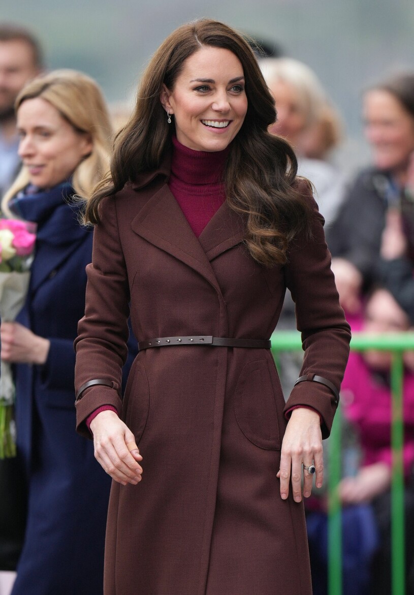 kate middleton i en vinröd kappa med skärp i midjan