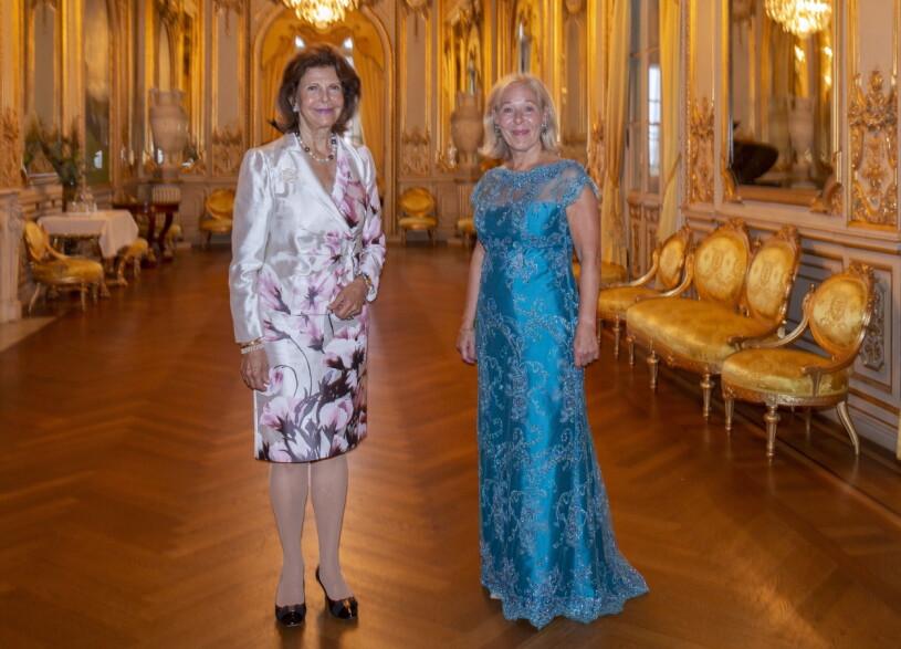 Drottning Silvia i sin glänsande sidendräkt med orkidéer. Operachefen Birgitta Svendén bar himmelsblå spetsar. Drottning Silvia och Birgitta Svendén, VD Kungliga Operan