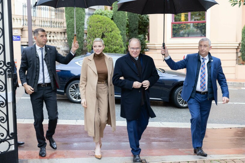 Charlene och Albert gör furstlig entré. Furstinnan Charlene och furst Albert i regnet, får hjälp med att hålla paraplyerna