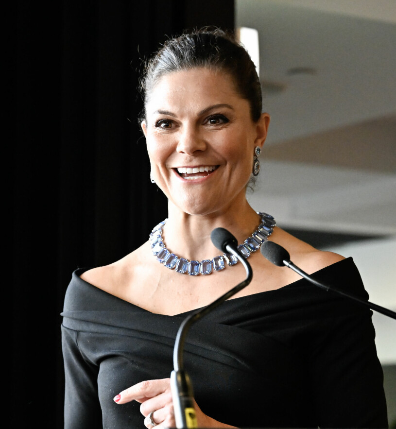 Kvällens outfit: Blåblommig kjol, svart topp – och så detta statementhalsband. Kronprinsessan Victoria håller tal, klädd i en svart off the shoulders topp