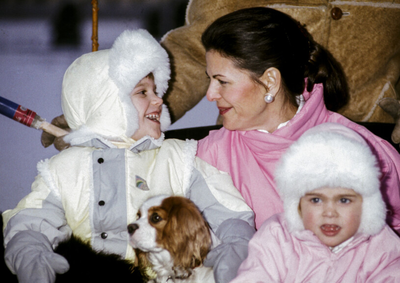 Carl Philip och Silvia har alltid haft en väldigt fin relation. Prins Carl Philip med en hundvalp i famnen ler glatt mot drottning Silvia bakom prinsessan Madeleine vid en slädtur tillsammans med kungafamiljen vintern 1985.