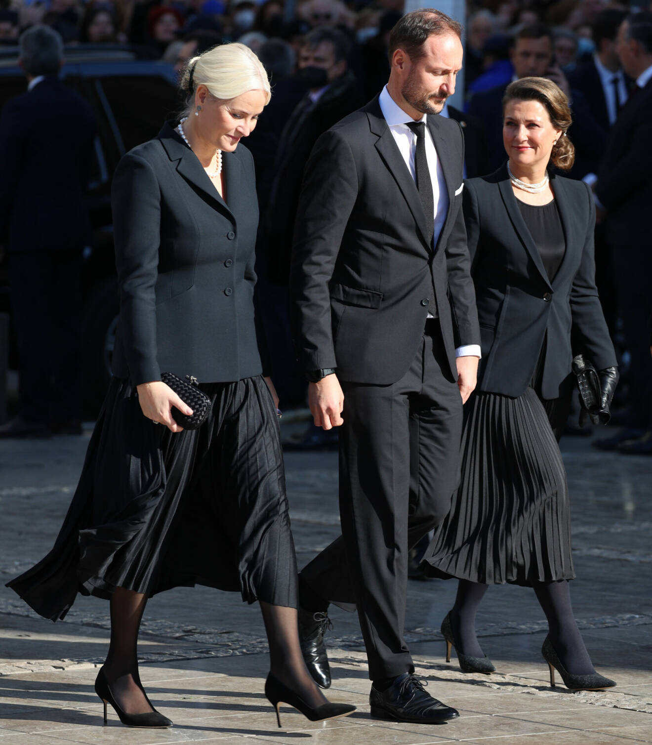 Kronprinsessan Mette-Marit och prinsessan Märtha Louise i svart plisserad kjol på kung Konstantins begravning i Aten