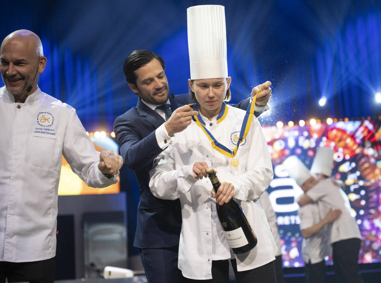 Prins Carl Philip hänger medaljen om halsen på kocken Desirée Jaks, vinnare av Årets kock 2023 efter finalen som avgjordes i Annexet vid Globen.