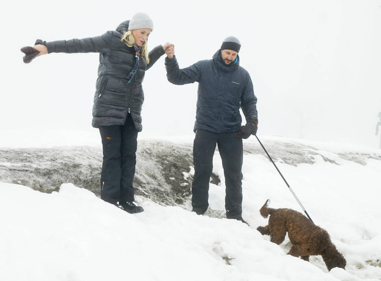 Kronprinsessan Mette-Marit får en hjälpande hand av kronprins Haakon
