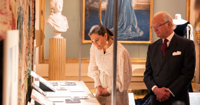 Kronprinsessan Victoria och kungen tittar på historiska bilder från kronprinsessan Margaretas liv. Kronprinsessan Victoria och kung Carl Gustaf