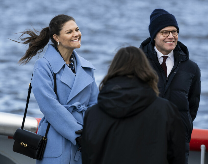 Vild hästsvans på Victoria. Prins Daniel hade det lugnare på hårfronten, han valde mössa. Kronprinsessan Victoria och prins Daniel i Luleå Hamn