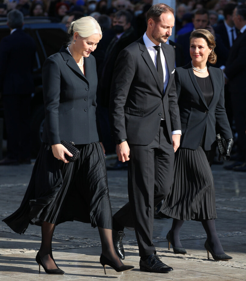Kronprinsessan Mette-Marit och prinsessan Märtha Louise i svart plisserad kjol på kung Konstantins begravning i Aten