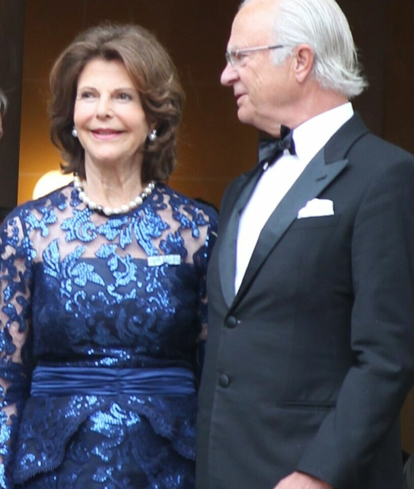 Kungen och drottning Silvia – i höst har det gått 50 år sedan de träffades och blev ett par! Drottning Silvia i en blå paljettklänning från Camilla Thulin. Kungen i smoking.