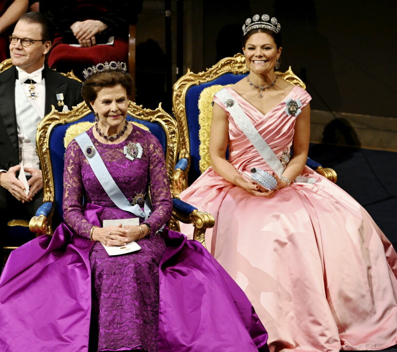 Drottning Silvia går i starkt cerise och kronprinsessan Victoria i laxrosa. Cool kombo! Kronprinsessan Victoria och drottning Silvia på Nobel 2022