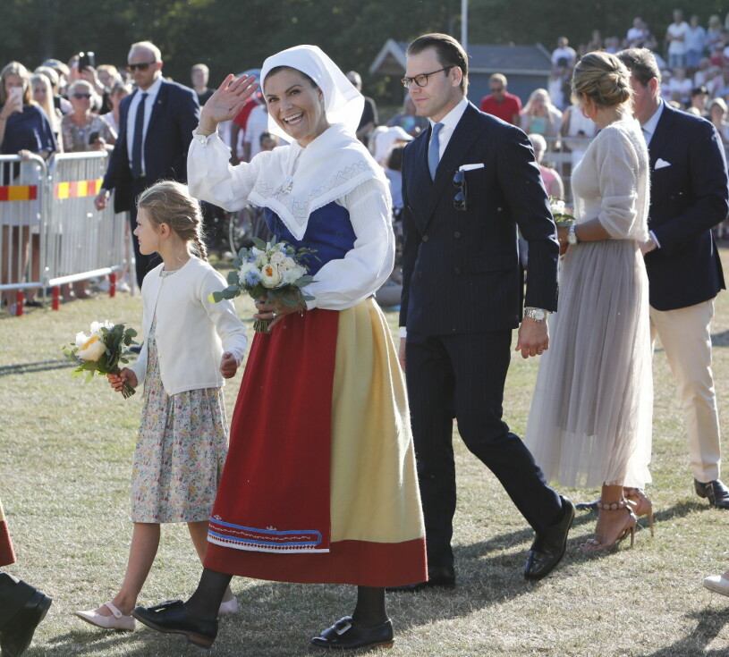 Victoria i Ölandsdräkt – medan Daniel matchar med den kritstrecksrandiga businesskostymen. Kronprinsessan Victoria Ölandsdräkt Prins Daniel kostym Kunglig klädkod