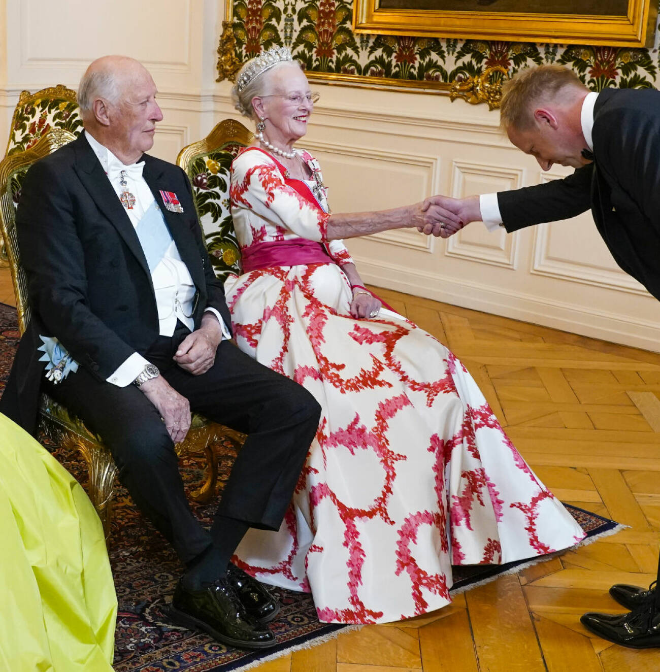 Kung Harald och drottning Margrethe hälsar sittande vid galamiddagen på Amalienborg i Köpenhamn