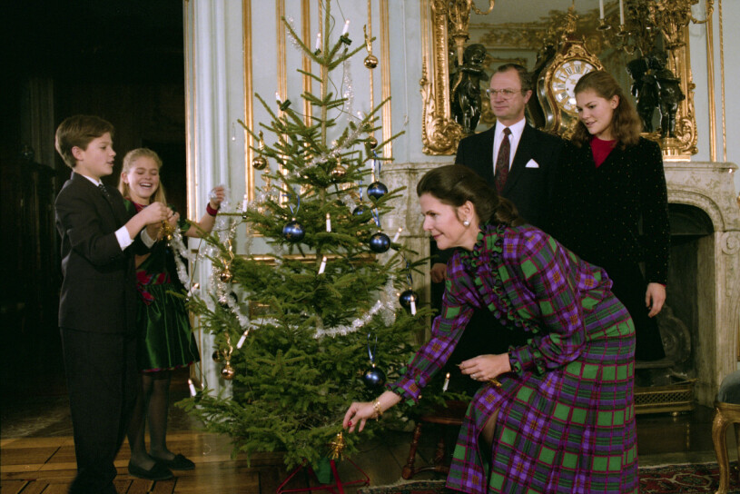 Kungafamiljen firar jul precis som andra familjer. Här klär de granen på Stockholms slott den 21:a december 1992. Svenska kungafamiljen fr. v. prins Carl Philip prinsessan Madeleine, drottning Silvia, kung Carl XVI Gustaf och kronprinsessan Victoria klär julgranen under den årliga julfotograferingen på Stockholms slott 21:a december 1992.