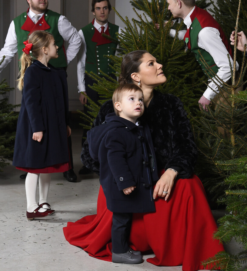 Det är så här det brukar se ut, med de kungliga barnen som tända ljus framför granarna. Prinsessan Estelle och prins Oscar framför julgranar på slottet