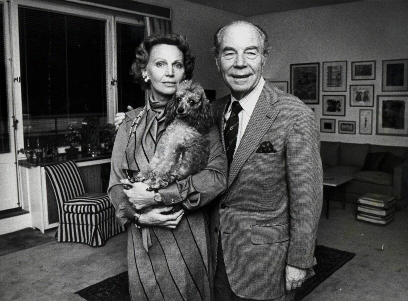 Sigvard och Marianne Bernadotte. Marianne håller parets pudel i famnen. Paret poserar i vardagsrummet i hemmet, året är 1976.