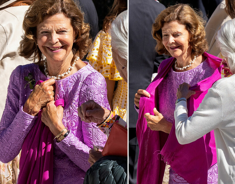 På solig vänträff i Medevi Brunn i violett siden och med en värmande pashminasjal över axlarna. Drottning Silvia i ljuslila klänning