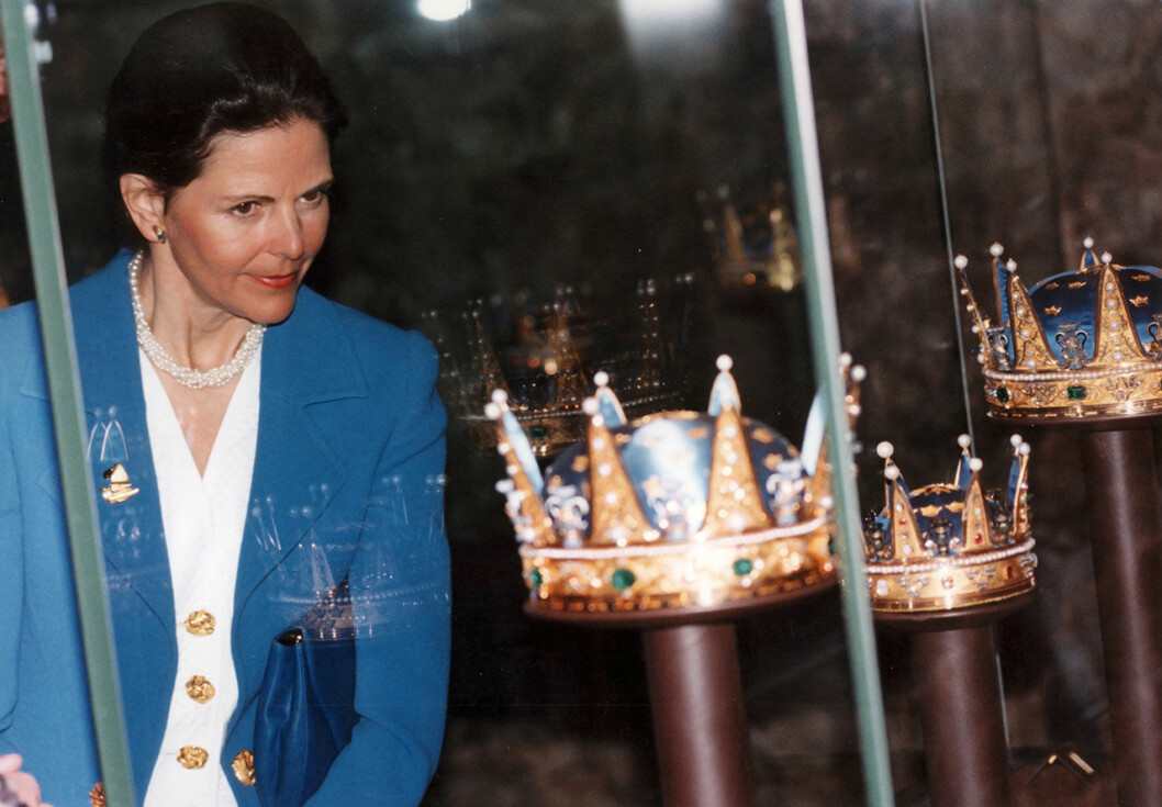 Drottning Silvia tittar på kungakronorna i montern i skattkammaren på det kungliga slottet i Stockholm 13:e april, 1994, vid en guidad tur med det finska presidentparet Martti och Eeva Ahtisaari under presidentparets tre dagars besök till Sverige. Drottning Silvia