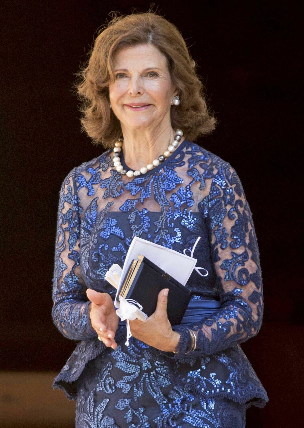 Drottning Silvia på sin brorsdotters bröllop på Mallorca, klädd i en spetsklänning designad av Camilla Thulin.