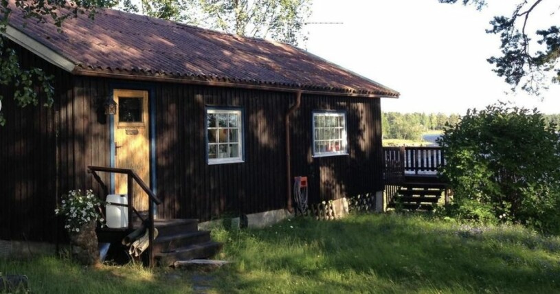 En av de bruna timmerstugorna på tomten.