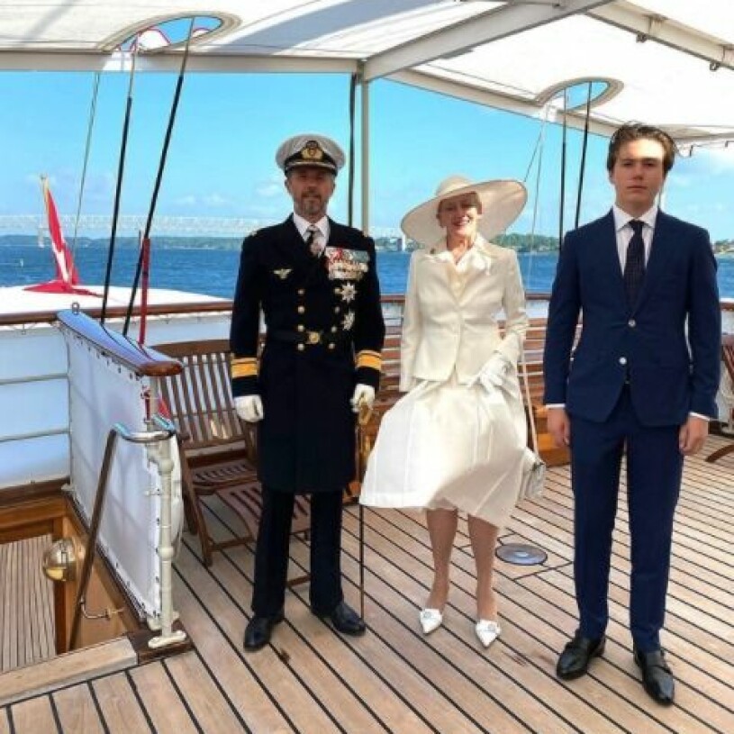 Margrethe i sommarvitt, Kronprins Frederik i paraduniform och prins Christian i kostym från italienska Loro Piana. Kronprins Frederik Drottning Margrethe Prins Christian ombord på Dannebrog 2021