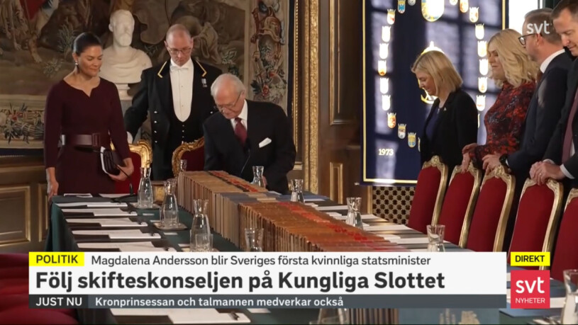 Kronprinsessan Victoria vid kungens sida, för dagen klädd i en vinröd klänning från Camilla Thulin. Mannen som skymtar bakom dem är hovfurir Jerry Carlde. Kronprinsessan Victoria Kungen Skifteskonselj slottet Magdalena Andersson