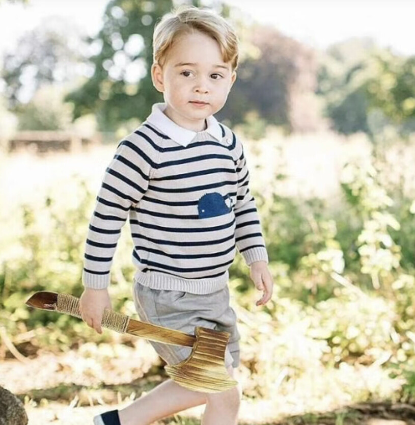 Fejkbilden på prins George med ett leksaksvapen i handen. Prins George med ett leksaksvapen i handen