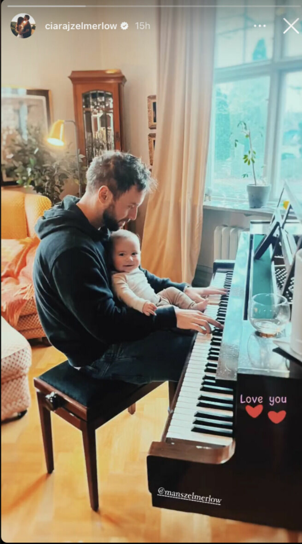En bild från Ciara Zelmerlöws Instagram på Måns Zelmerlöw med sonen Ossian i knät framför ett piano