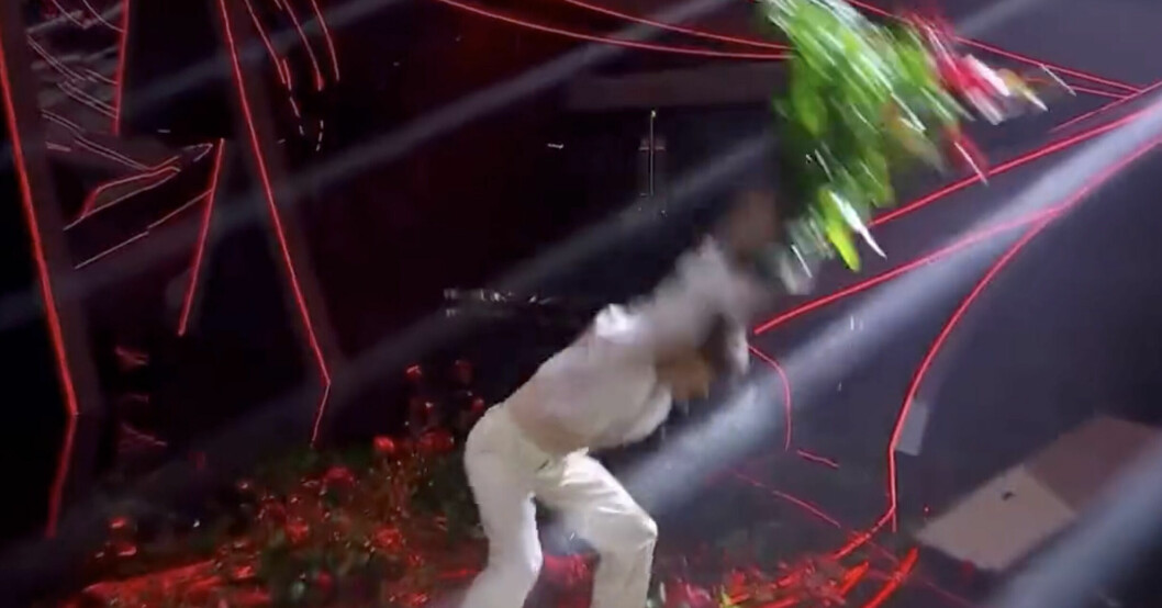 Blanco kastar blommor på scen