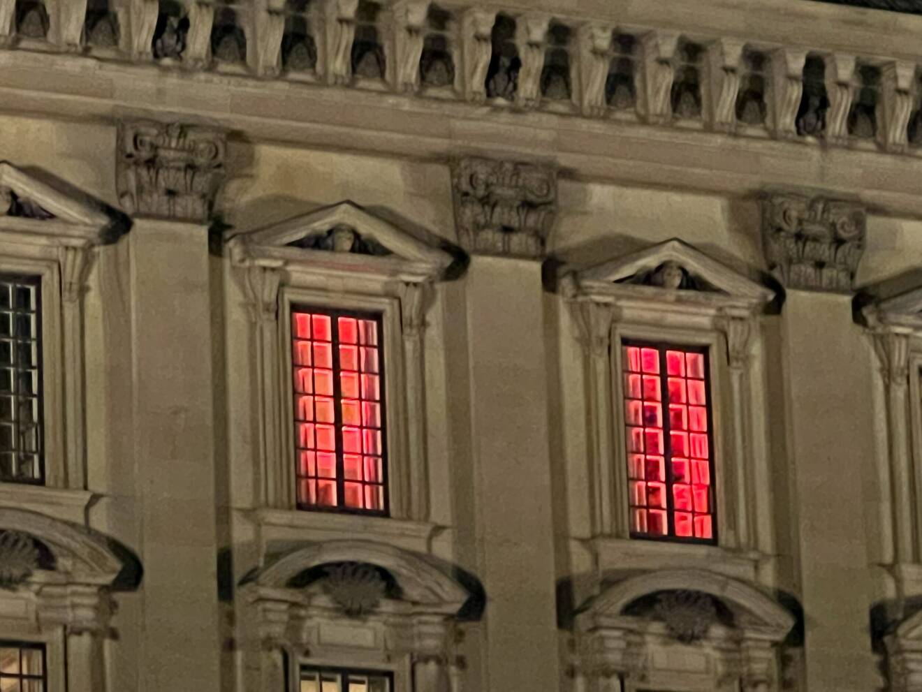 En bild på två fönster i slottet med röd belysning