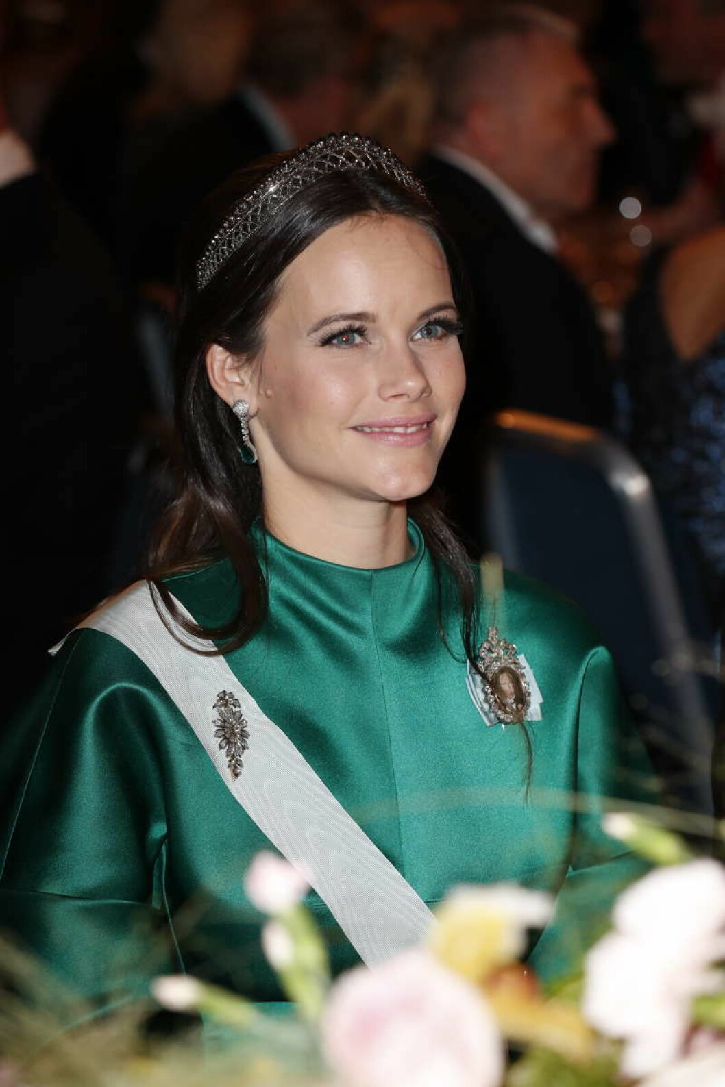 Hon bar den med en diskret tiara och eleganta smaragdörhängen.
