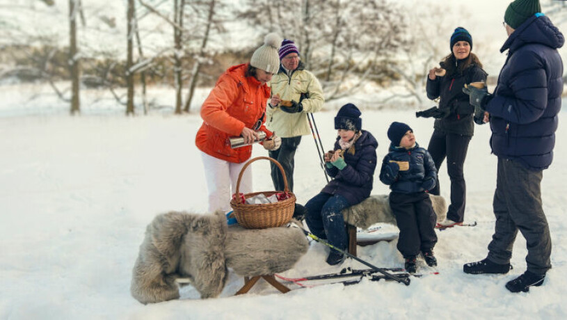 Mormor Silvia delar ut varm choklad på vinterpicknicken. Kungen och drottning Silvia med barnbarnen i snön på Drottningholm