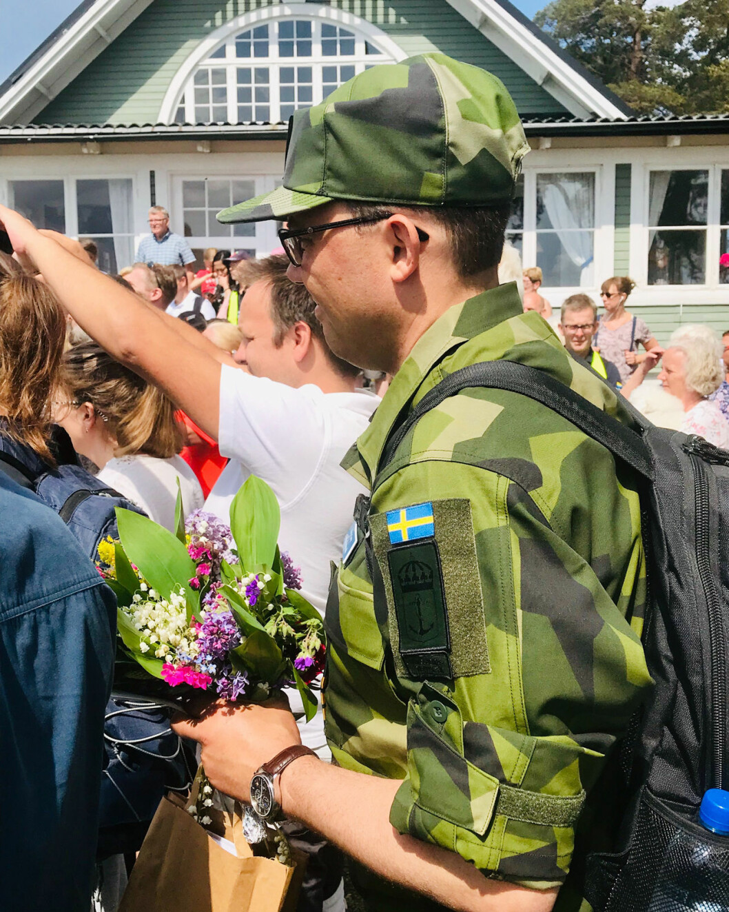 Adjutanten med några av dagens alla buketter. Kronprinsessan Victorias adjutant Jonas Forsmark.
