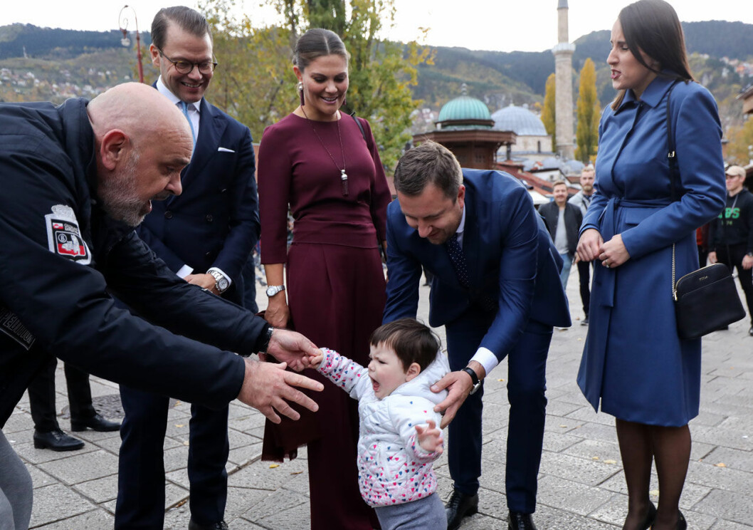 Vilken liten glädjespridare! Kronprinsessan Victoria och prins Daniel träffar ett litet barn i Sarajevo, Bosnien.