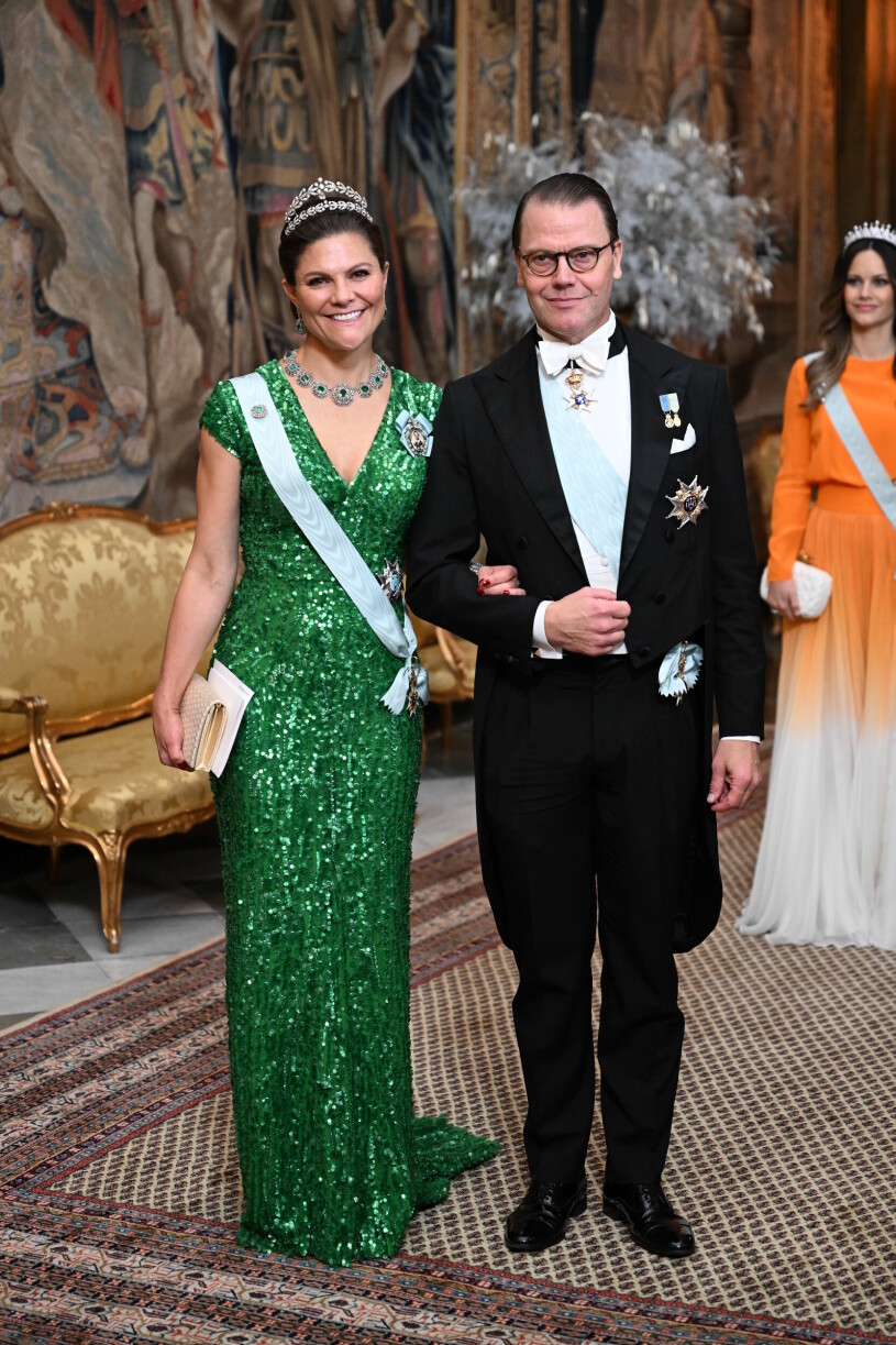 Kronprinsessan Victoria i en grön paljettklänning bredvid prins Daniel på middag på slottet