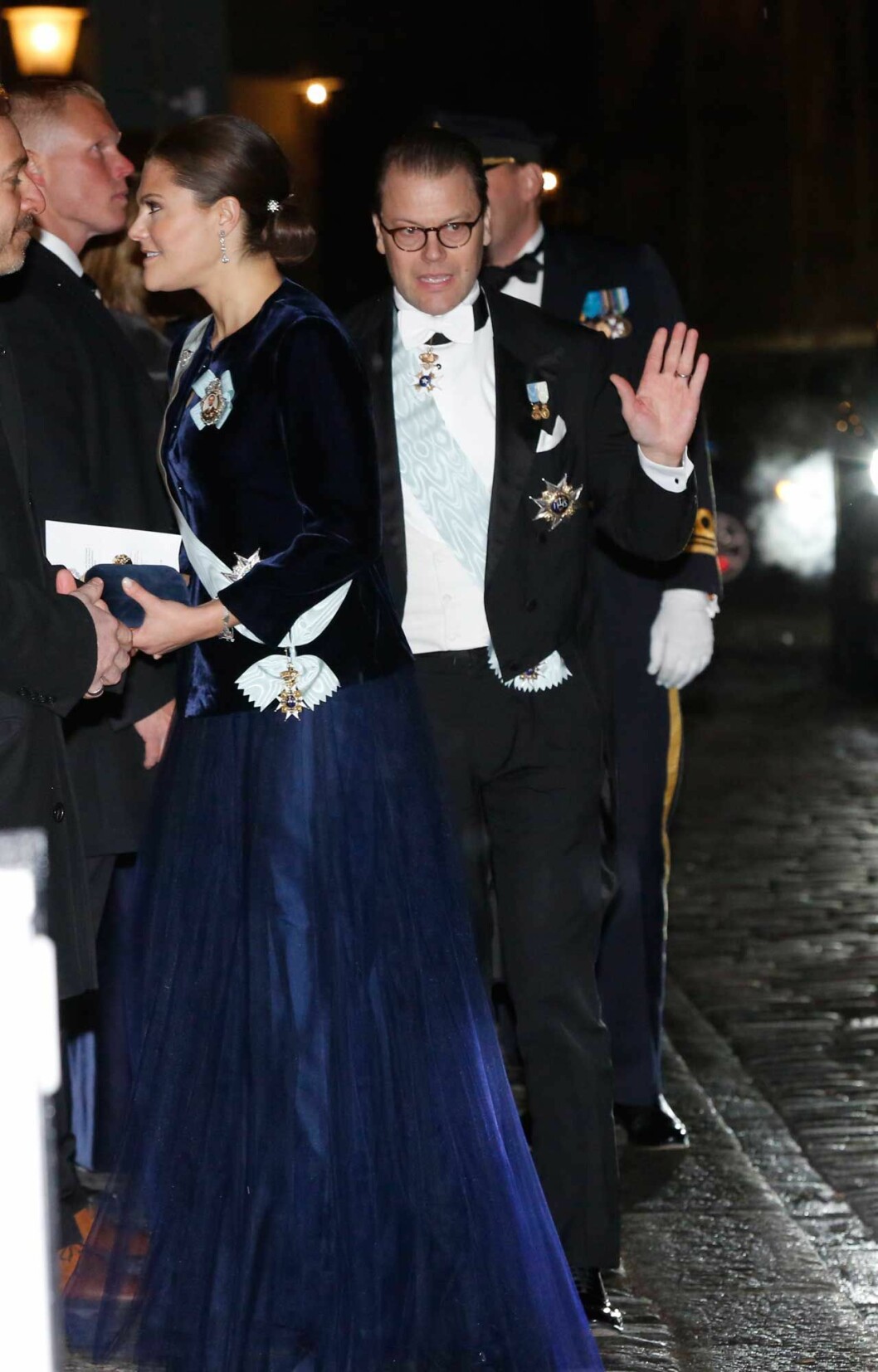 Kronprinsessan Victoria och prins Daniel kom gående hand i hand (vilket tyvärr inte syns här). Men hur var det med klänningen, var den svart eller mörkt midnattsblå? Kronprinsessan Victoria och prins Daniel anländer till Svenska Akademiens högtidssammankomst. Hennes klänning skiftade färg, blå ibland och svart ibland.