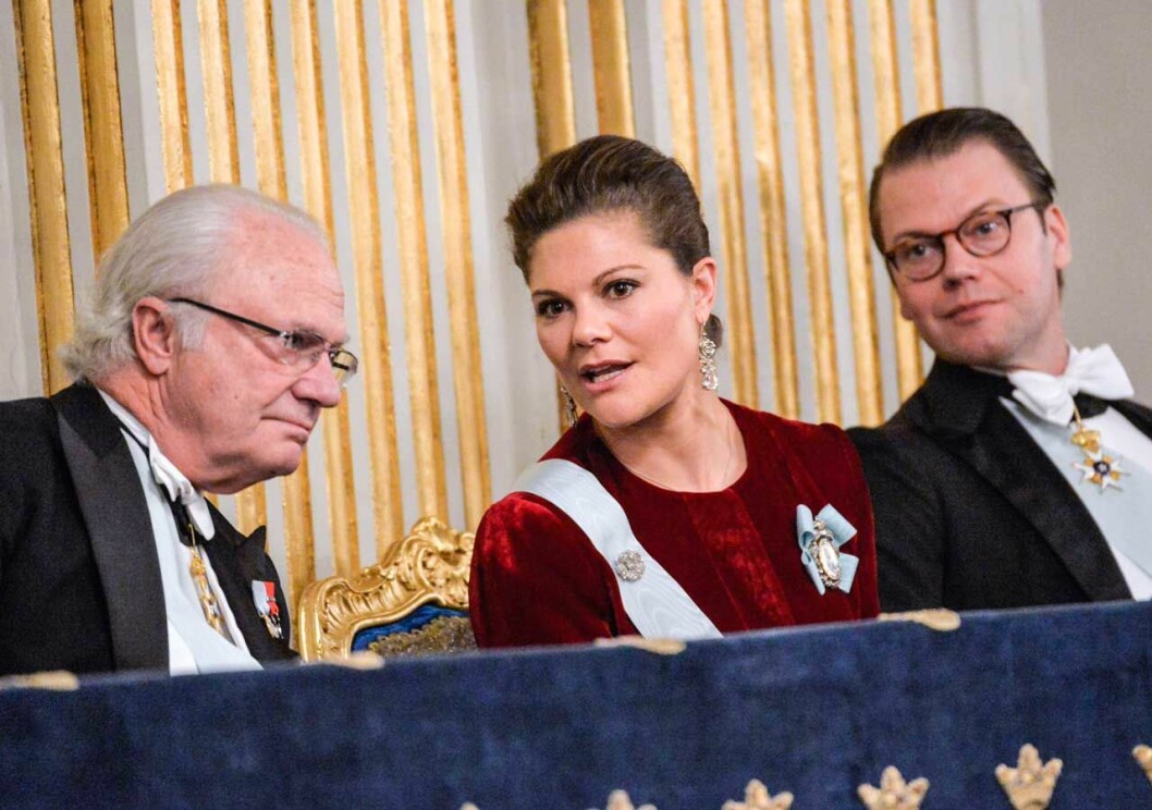 Kungen sätter ner foten. Kungen, kronprinsessan Victoria och prins Daniel vid Svenska Akademiens högtidssammankomst. Nu sätter kungen ner foten om kungafamiljens närvaro.