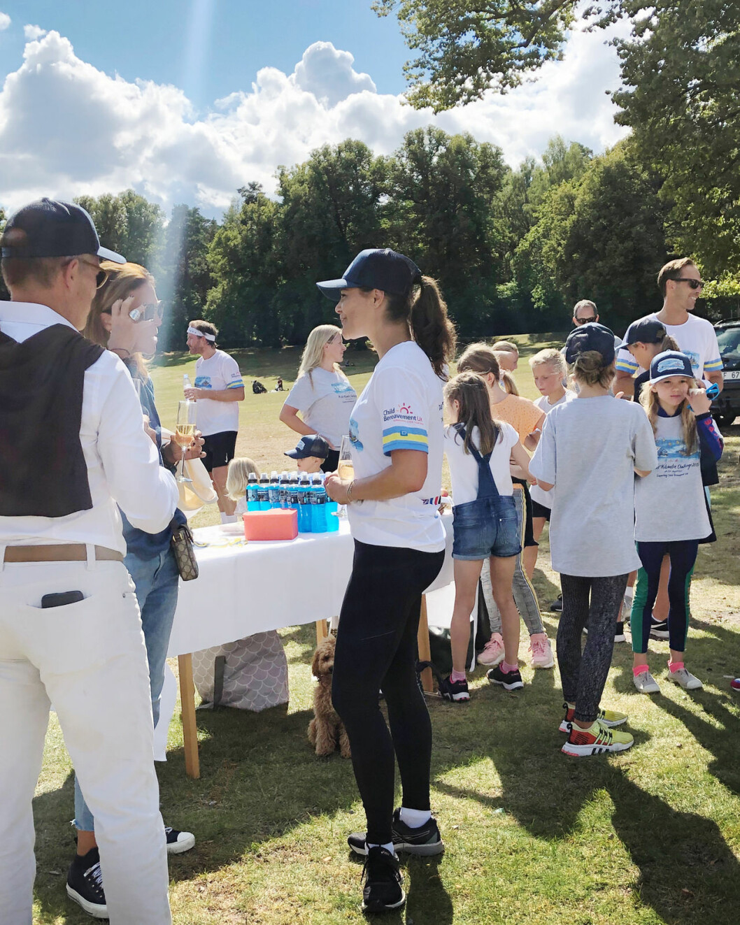 Kronprinsessan minglade runt i sensommarsolen, och i bakgrunden skymtar Cristina Stenbeck. Kronprinsessan Victoria prins Daniel prinsessan Estelle hunden Rio